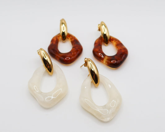Set of earrings with amber and gold accents on a light gray background
