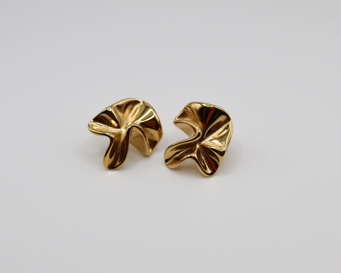 Pair of gold earrings on a light gray background