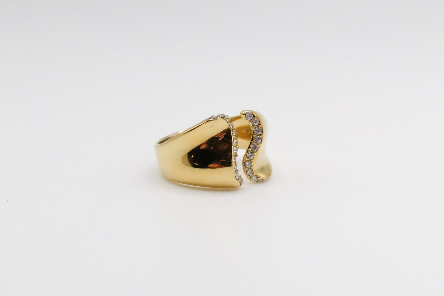 Gold ring with a brown gemstone on a light gray background