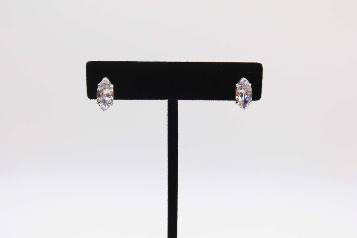 Pair of earrings on a black earring stand against a white background