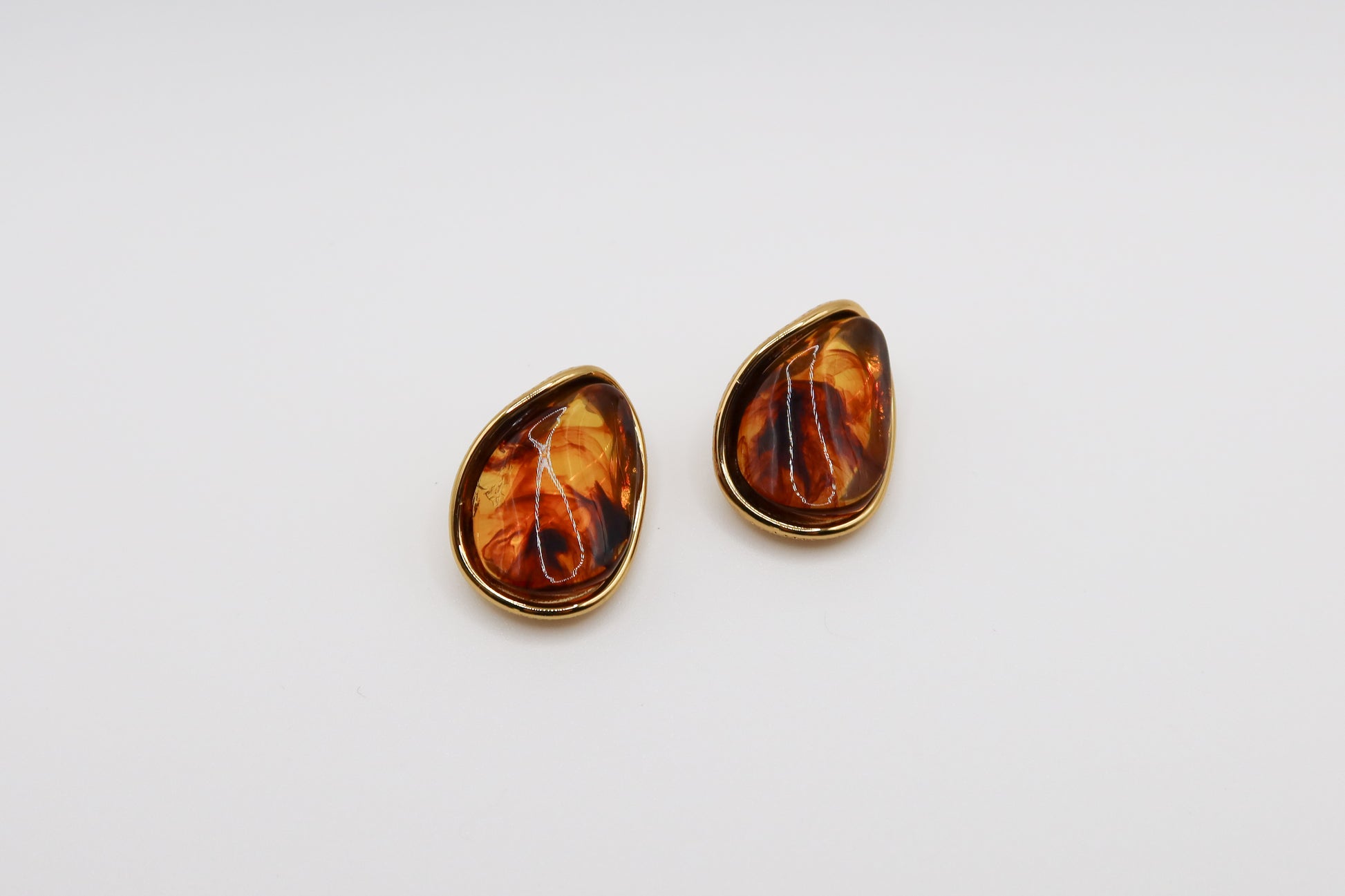 Pair of amber teardrop earrings on a white background