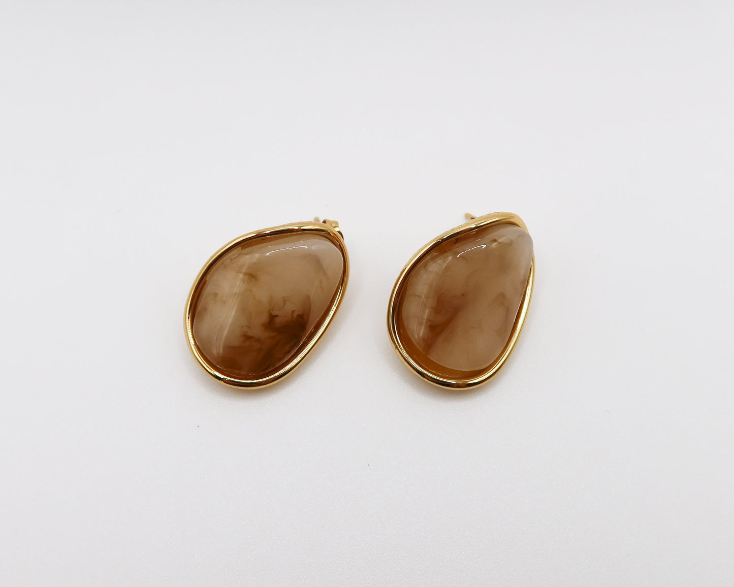 Pair of gold-framed khaki stone earrings on a white background
