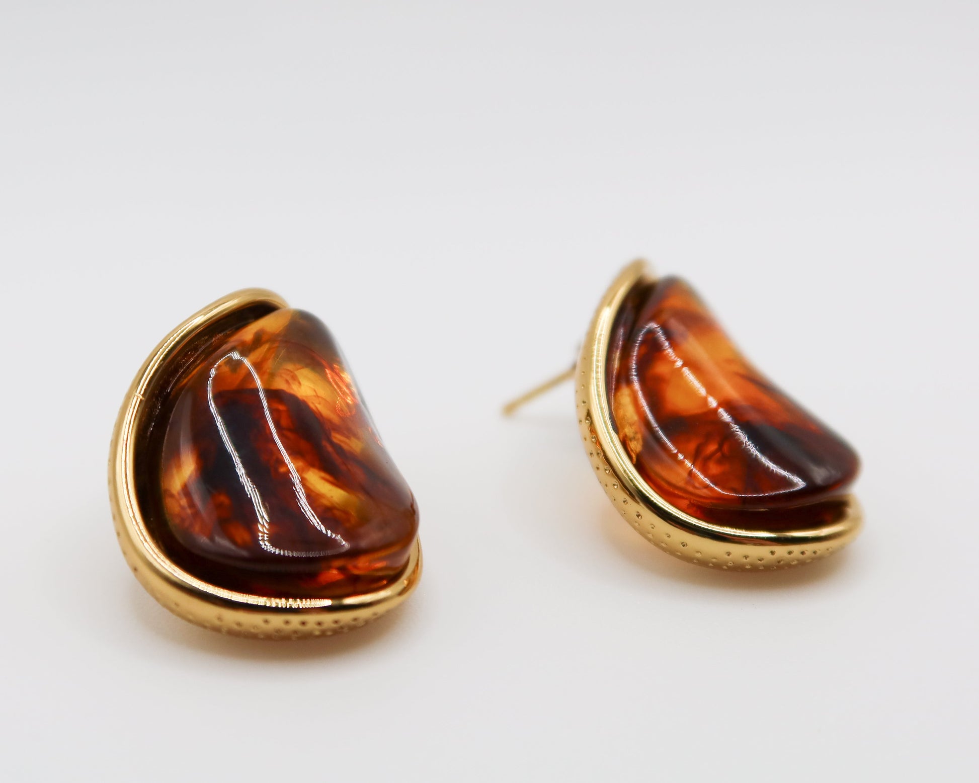 amber earrings with gold accents on a white background