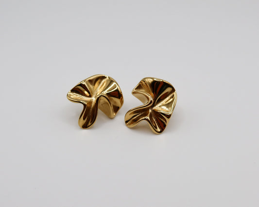 Pair of gold earrings on a light gray background