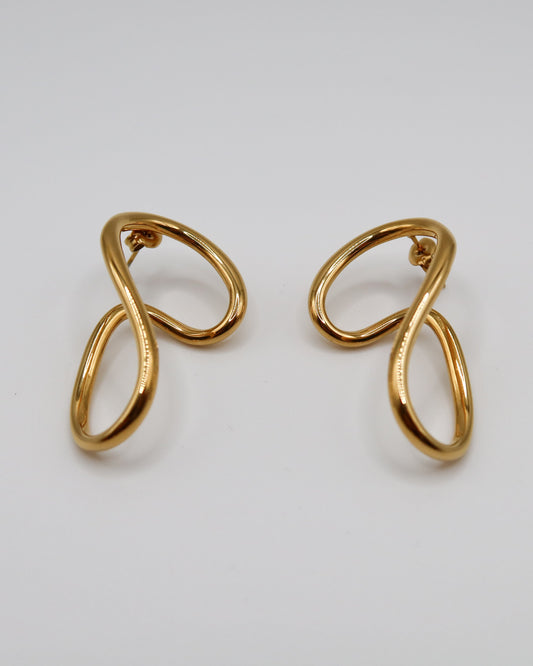 Pair of gold earrings on a light gray background