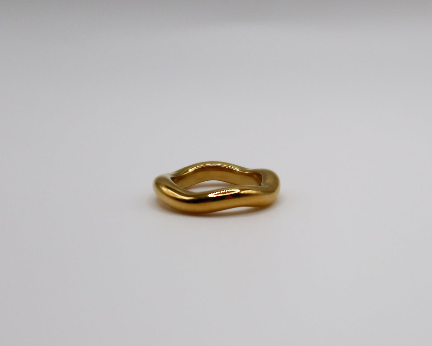Gold ring on a light gray background