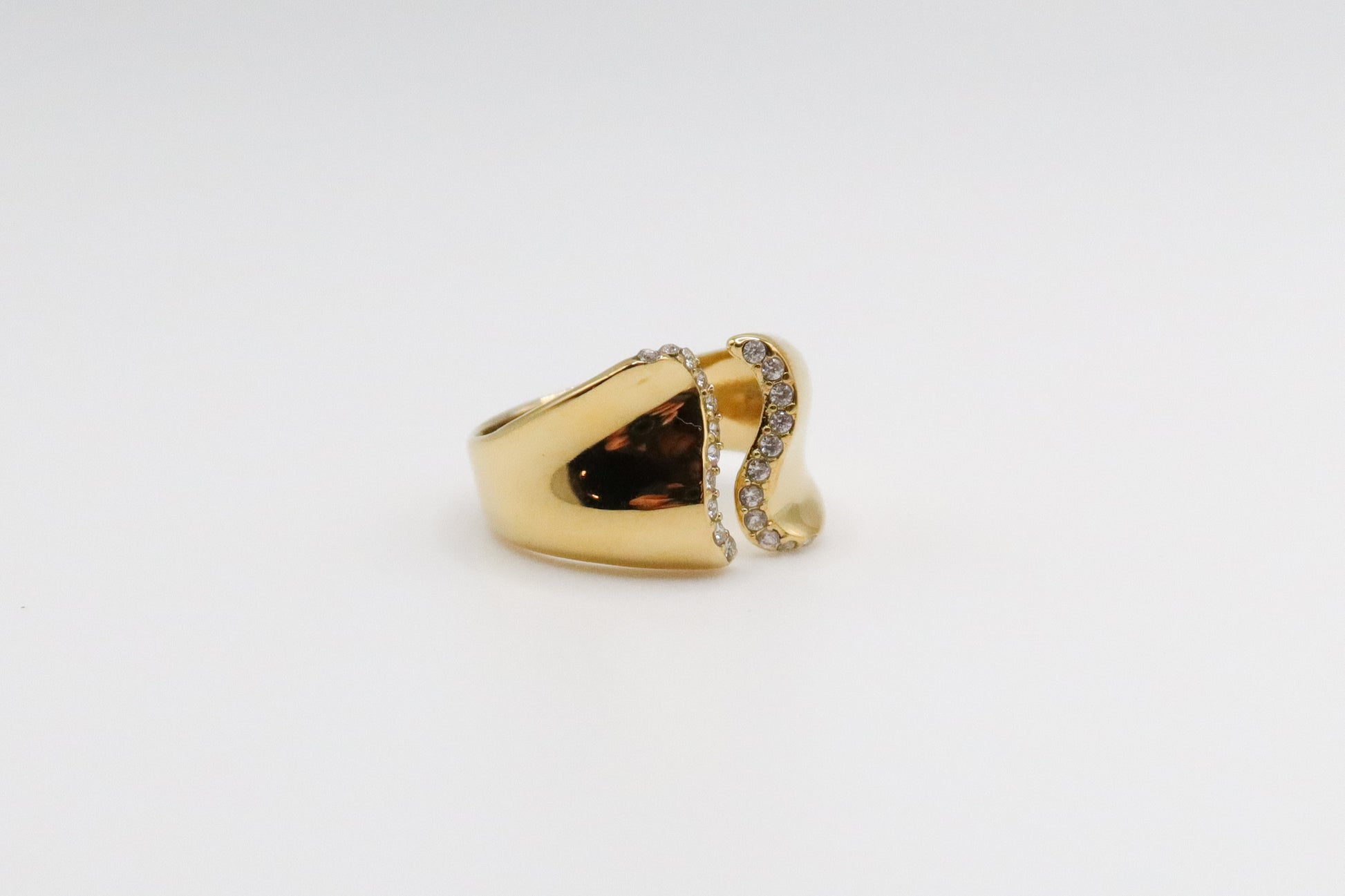 Gold ring with a brown gemstone on a light gray background
