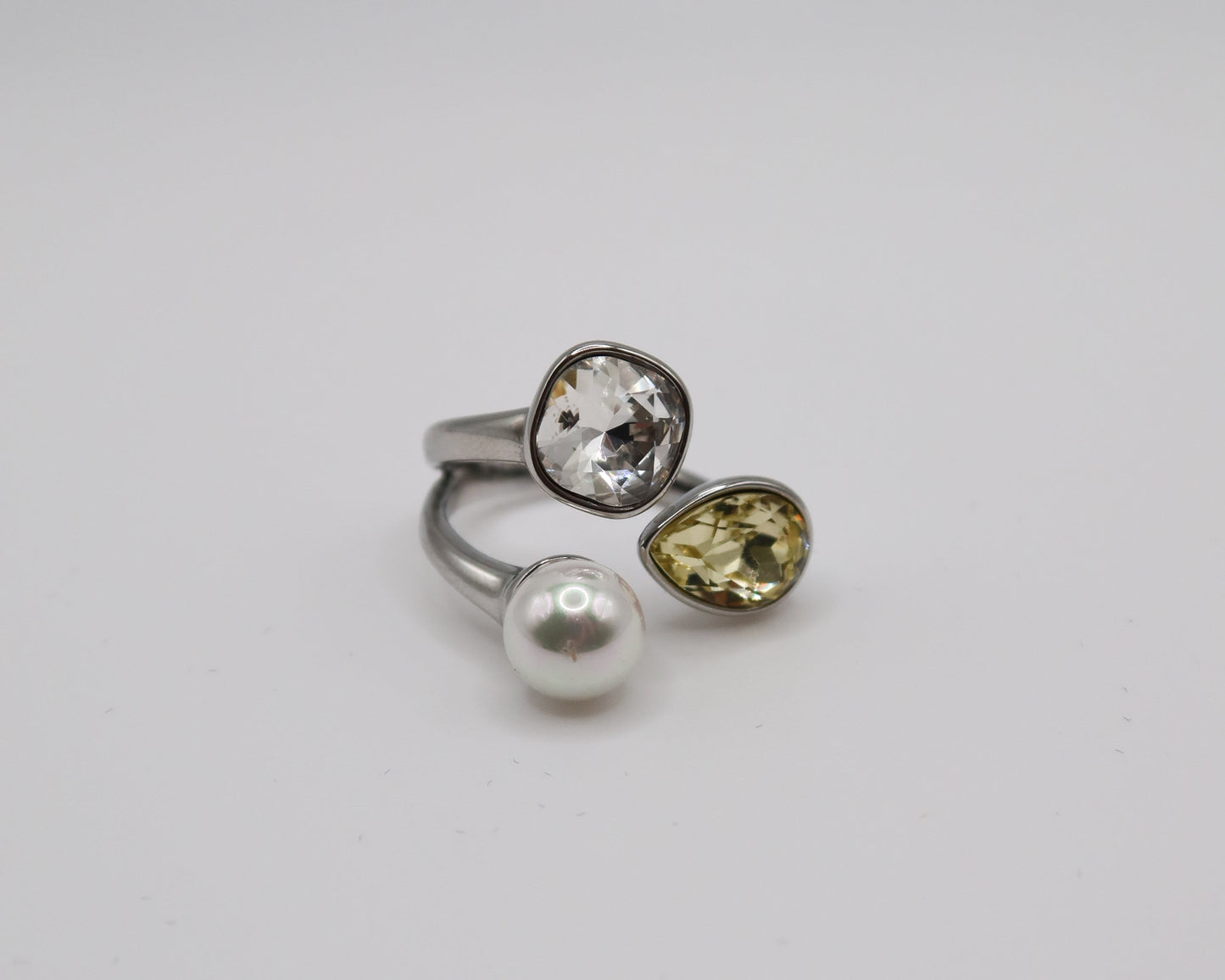 Three rings with different gemstones on a light gray background