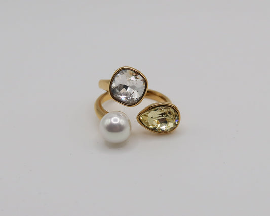 Three gold rings with gemstones on a light gray background
