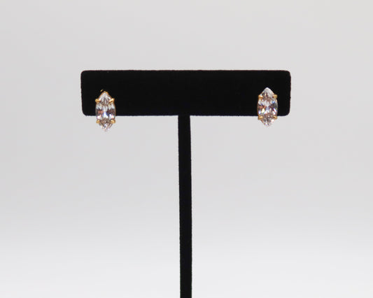 Pair of earrings on a black earring stand against a light gray background