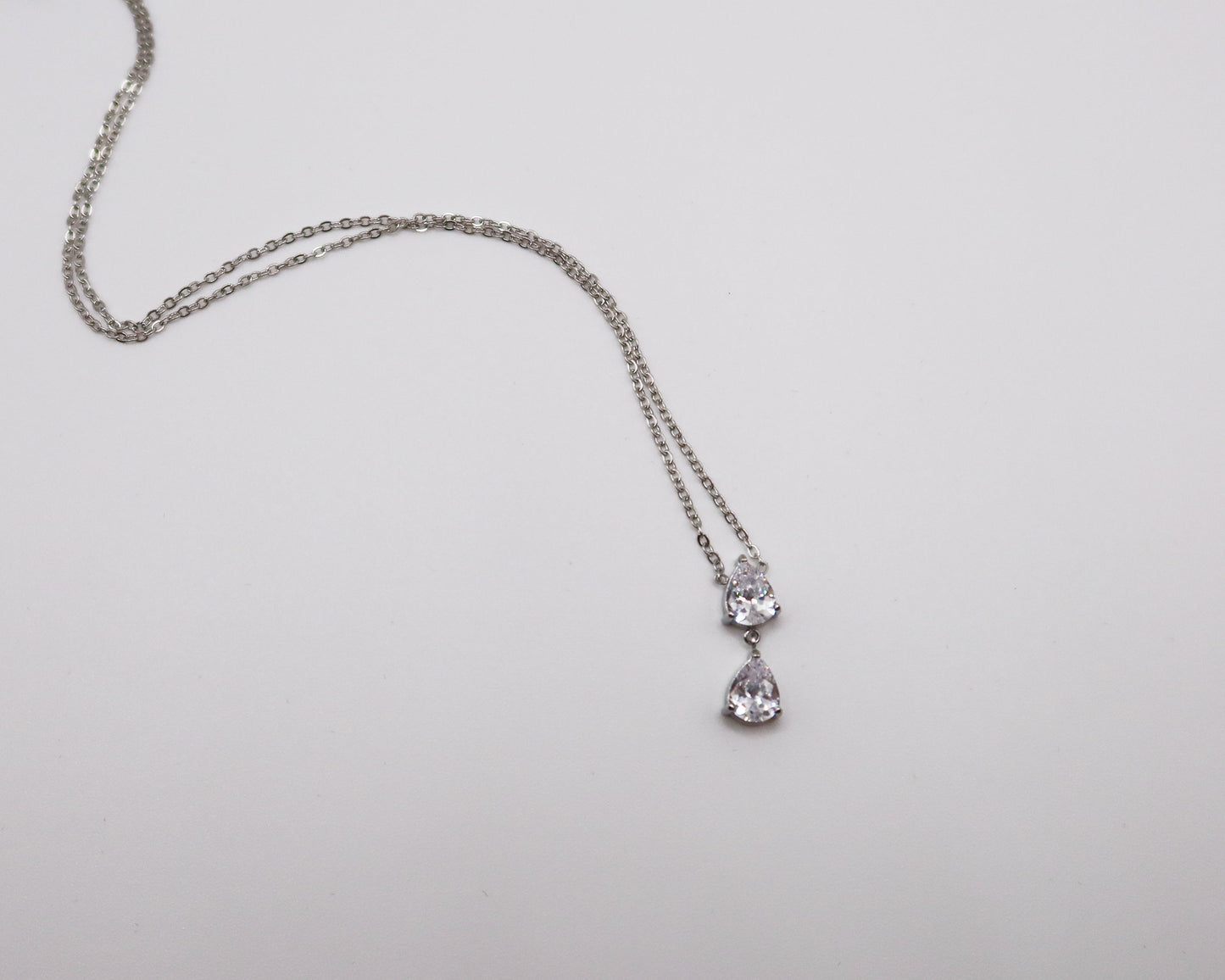Silver necklace with a pendant on a light gray background