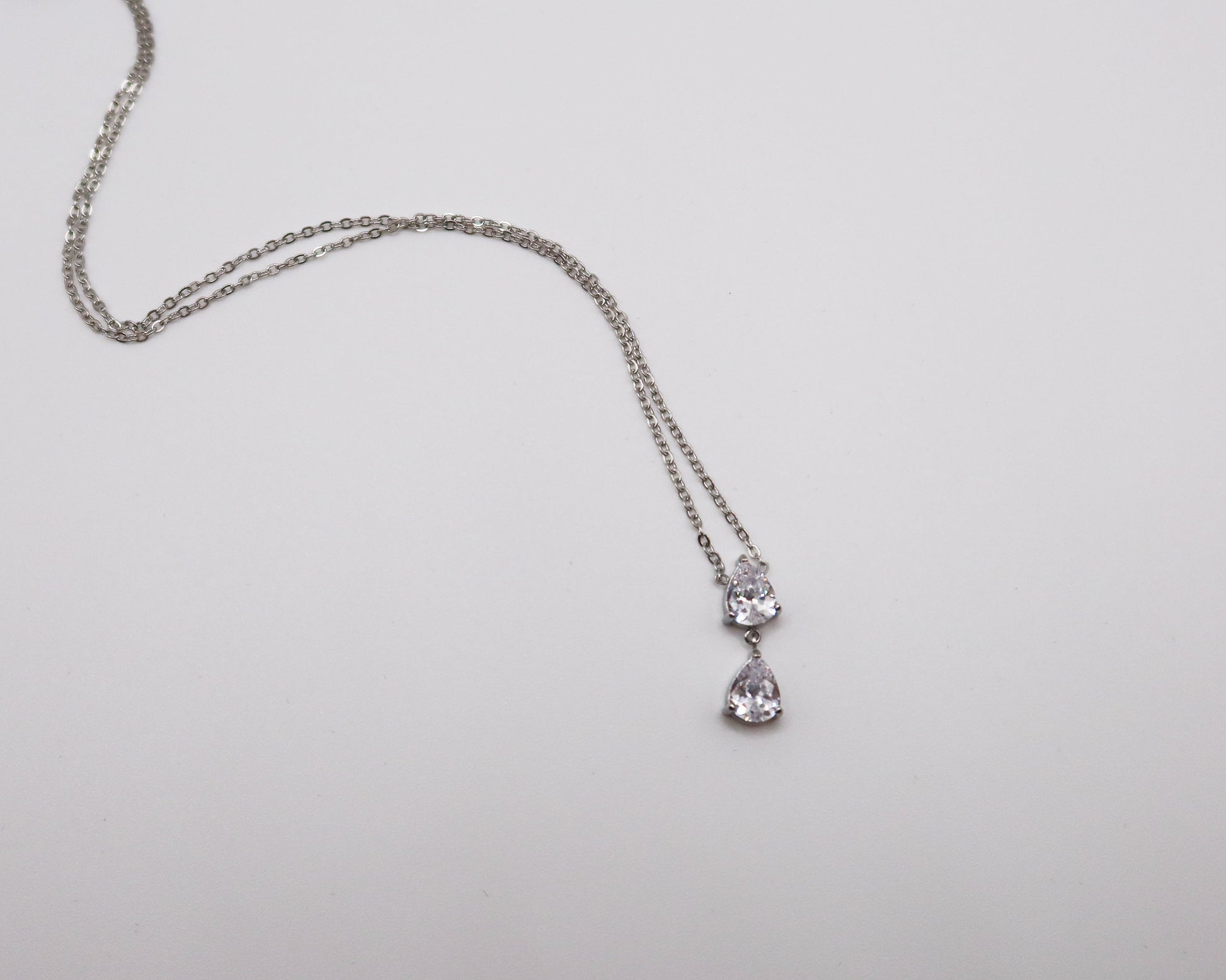 Silver necklace with a pendant on a light gray background